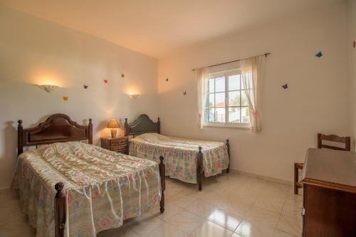 1 dormitorio con 2 camas y ventana en Villa Sesmarias, en Carvoeiro