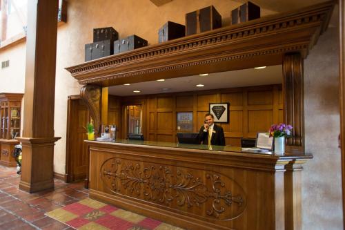 a man is standing behind a reception desk in a lobby at Pillar and Post Inn & Spa in Niagara-on-the-Lake