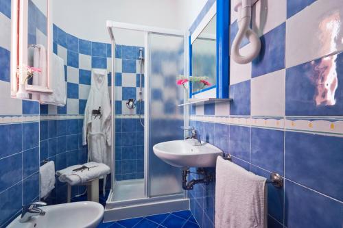 a blue tiled bathroom with a sink and a shower at Hotel Meeting in Cesenatico