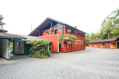 a row of red buildings in a parking lot at MOTEL 3 PEIXINHOS (Adults Only) in Blumenau