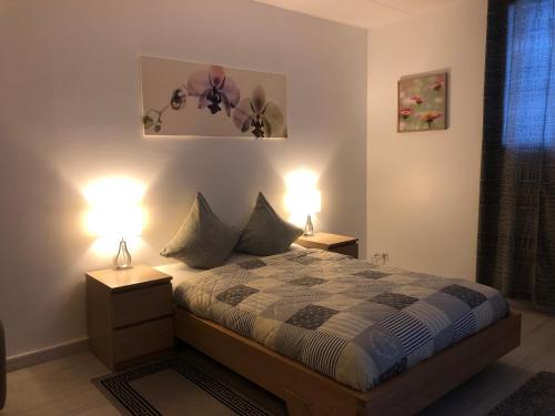 a bedroom with a bed with two lamps on it at Auberge Pour Tous in Vallorbe