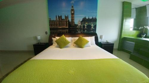 a bedroom with a large bed with a yellow blanket at Hotel Campestre El Cisne in Barranquilla