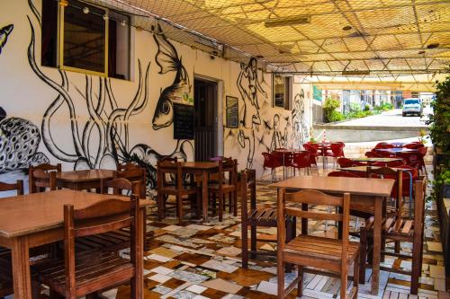 a restaurant with tables and chairs and a wall with graffiti at Residencial Sintanton Trekking in Ponta do Sol