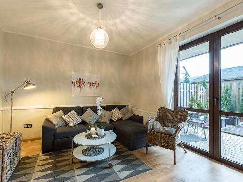 ein Wohnzimmer mit einem Sofa und einem Tisch in der Unterkunft VacationClub – Rezydencja Park II Apartament 1 in Mielno