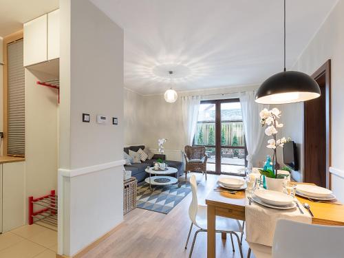 eine Küche und ein Wohnzimmer mit einem Tisch und einem Esszimmer in der Unterkunft VacationClub – Rezydencja Park II Apartament 1 in Mielno