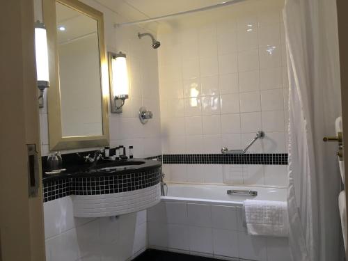 a bathroom with a tub and a sink and a mirror at Nuremore Estate in Carrickmacross