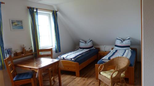 a bedroom with two twin beds and a table and a table at Ferienwohnung 2, Neuendorf - Hiddensee in Neuendorf