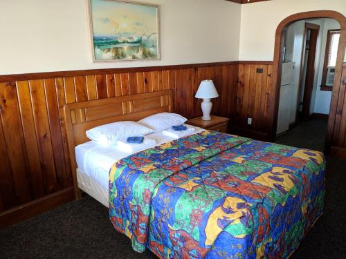 a bedroom with a bed with a colorful comforter at Cavalier by the Sea in Kill Devil Hills