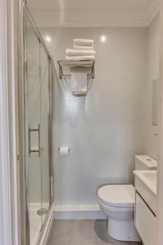 a white bathroom with a shower and a toilet at The Sportsview Guest House in Oxford