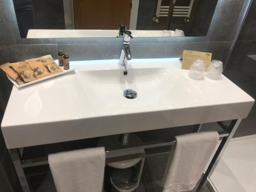 a white sink with two chairs in a bathroom at Hotel Madeira Centro in Benidorm