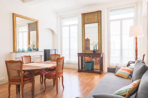 - un salon avec une table, des chaises et des miroirs dans l'établissement ACCI Cannes Riviera, à Cannes