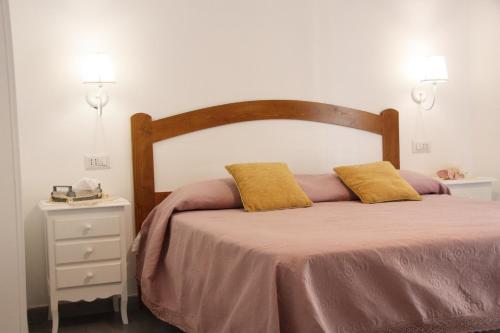 Una cama con dos almohadas amarillas encima. en Casa Amigdala en Castellabate