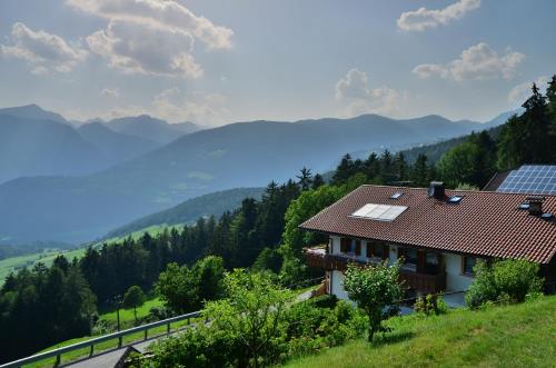 a house on a hill with a view of a mountain at Gruberhof in Rodengo