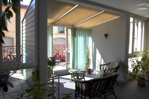 a balcony with chairs and a table and windows at Hotel de Bordeaux in Gramat