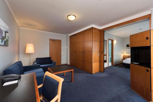 a living room with a couch and a table at Seminaris Hotel Potsdam Griebnitzsee in Potsdam