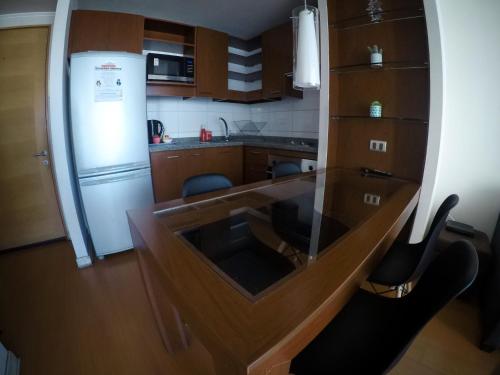 a kitchen with a glass table and a refrigerator at Departamentos Alto Libertad in Viña del Mar