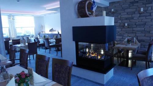 a restaurant with a fireplace in the dining room at Restaurant Hotel Goldener Adler in Emden