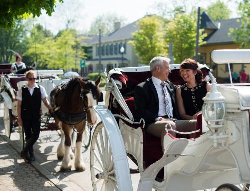 a man and woman riding in a horse drawn carriage at Prince of Wales in Niagara on the Lake