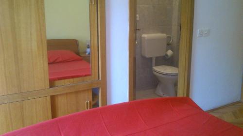 a small bathroom with a toilet and a red bench at room&4you in Supetar