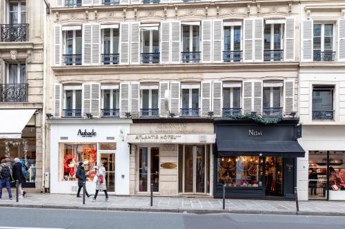 - un bâtiment dans une rue où les gens marchent devant dans l'établissement Hôtel Atlantis, à Paris