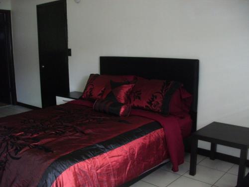1 dormitorio con 1 cama con edredón rojo en Newly Furnished Large Clean Quiet Private Unit en Fort Lauderdale