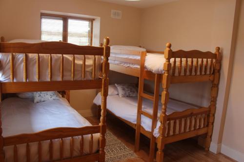 three bunk beds in a room with a window at The Beach House in Enniscrone