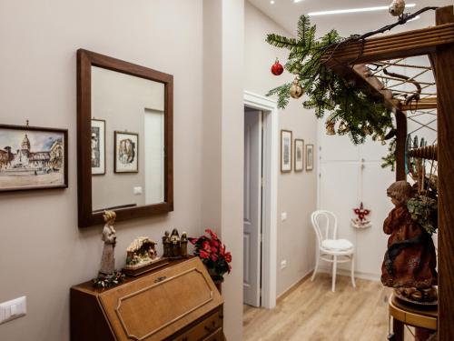 un couloir avec un miroir mural et une chaise dans l'établissement Armonia, à Salerne