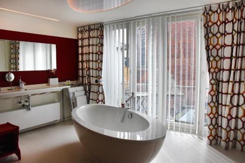 ein Badezimmer mit einer großen Badewanne vor einem Fenster in der Unterkunft Guesthouse PPP in Gent