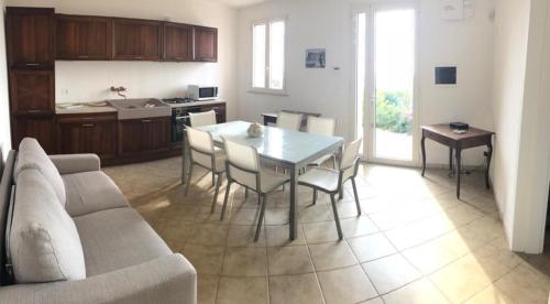 cocina y sala de estar con mesa y sillas en Villa Mariapaola, en Torre Vado