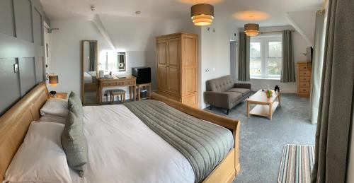 a bedroom with a large bed and a living room at Luccombe Hall Hotel in Shanklin