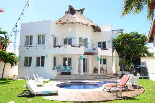 a villa with a swimming pool and a house at Bella Casa Privada junto al Mar Caribe in Cancún
