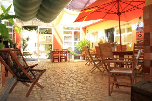 un patio con tavoli, sedie e ombrellone di Casa 3 Águias ad Aveiro