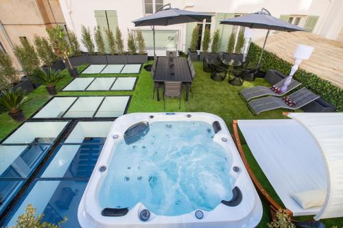 einen Whirlpool auf einer Terrasse mit einem Tisch und Stühlen in der Unterkunft Résidence Montaigne - Luxurious - 350m Palais - LRA Cannes in Cannes