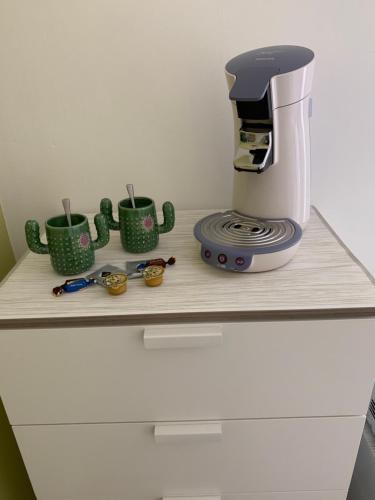 a coffee maker and cups on a wooden shelf at Carpe Diem in Jumet