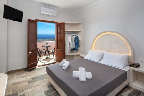 a bedroom with a bed and a balcony with the ocean at Nectarios Villa 2 in Fira