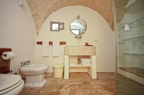 a bathroom with a sink toilet and a mirror at Masseria Ancella in Montalbano