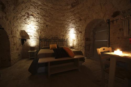 a bedroom with a bed and a table with a candle at Masseria Ancella in Montalbano