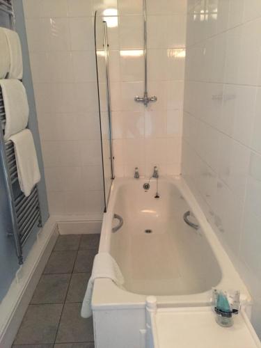 a bath tub in a bathroom with a shower at Willow Tree Cottages in Newark-on-Trent