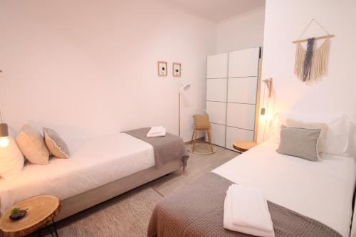 une chambre avec deux lits, une table et une chaise dans l'établissement Apartamento nas Olaias a 5 minutos da Faculdade ISEL e IST, à Lisbonne