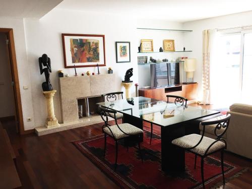 a living room with a table and chairs and a fireplace at Great Apartment in Meo Arena and Fil in Lisbon
