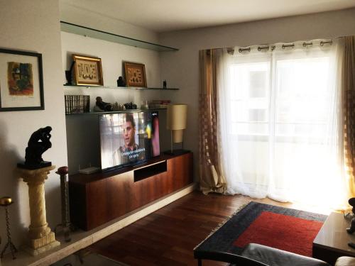 a living room with a tv and a window at Great Apartment in Meo Arena and Fil in Lisbon