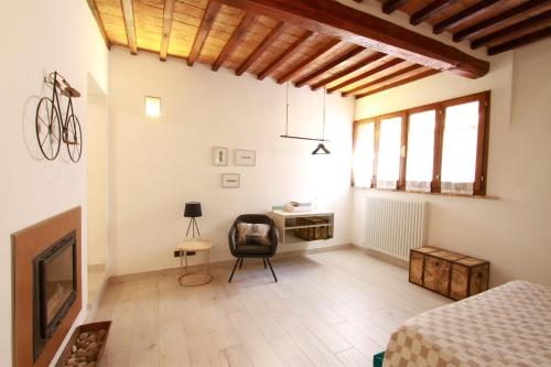 a bedroom with a bed and a desk and a fireplace at La Casa nel Borgo in Monticchiello