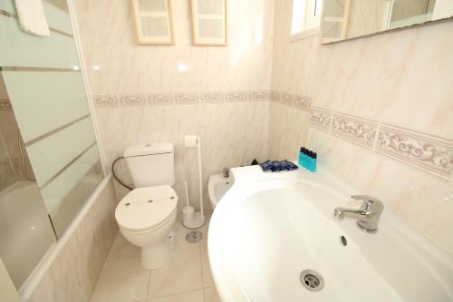 une salle de bain avec toilettes, baignoire et lavabo dans l'établissement Apartamento nas Olaias a 5 minutos da Faculdade ISEL e IST, à Lisbonne