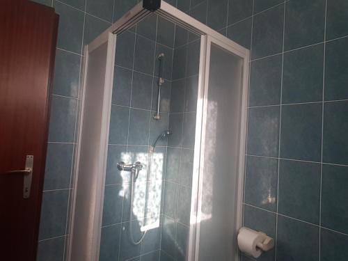 a bathroom with a shower with blue tiles at Apartments Zova in Medulin