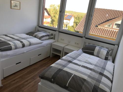 2 camas en una habitación con 2 ventanas en Ferienwohnungen Scheuring 2.OG, en Volkach