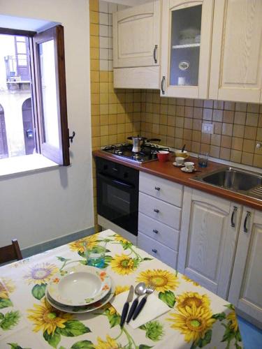 a kitchen with a table with a table cloth with flowers on it at Appartamento Garibaldi 142 in Castellammare del Golfo