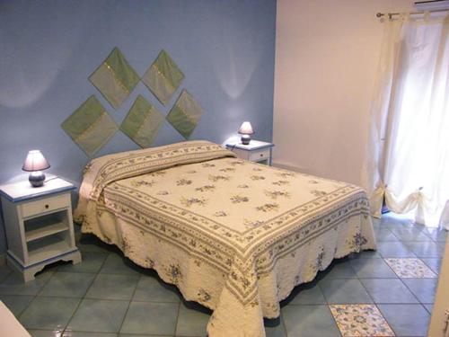 a bedroom with a bed and two night stands with lamps at Appartamento Garibaldi 142 in Castellammare del Golfo