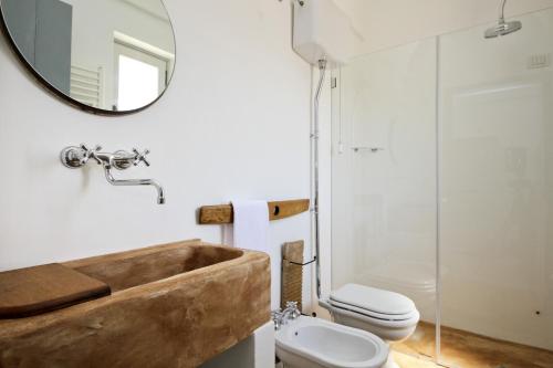 a bathroom with a wooden sink and a toilet at Masseria Ancella in Montalbano
