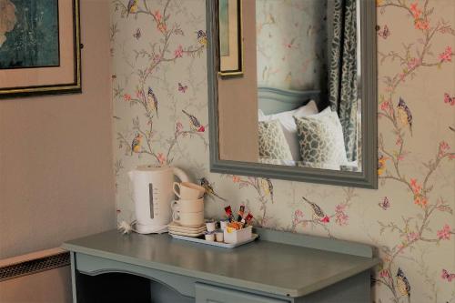 a mirror on a wall next to a table at The Waterfront Townhouse Accommodation in Kilkenny