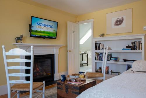 a bedroom with a fireplace and a tv on the wall at Liberty Hill Inn in Yarmouth
